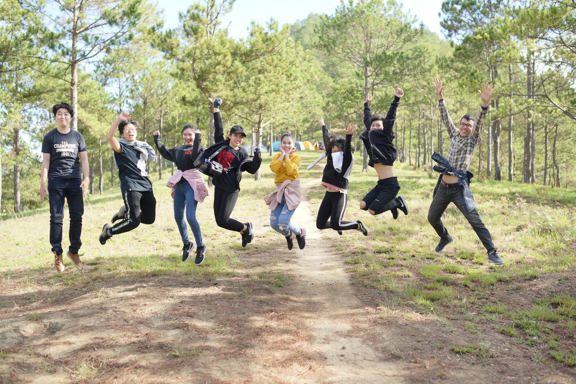 Group of students jumping in a forest