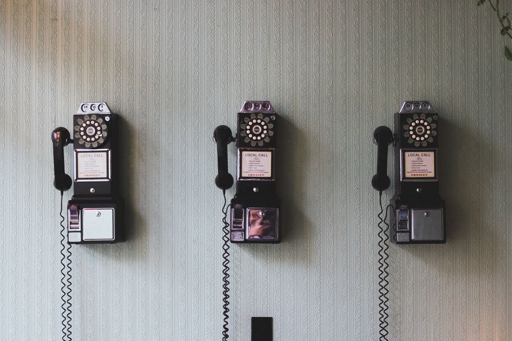 Image of three telephones on a wall