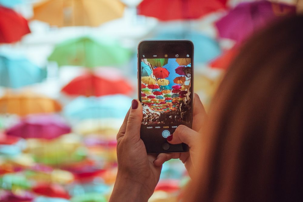 Woman taking a picture of colourful umbrellas