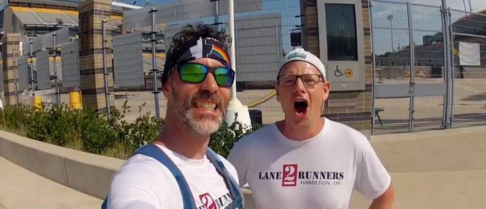 Two people looking at the camera wearing Lane 2 Runners t-shirts